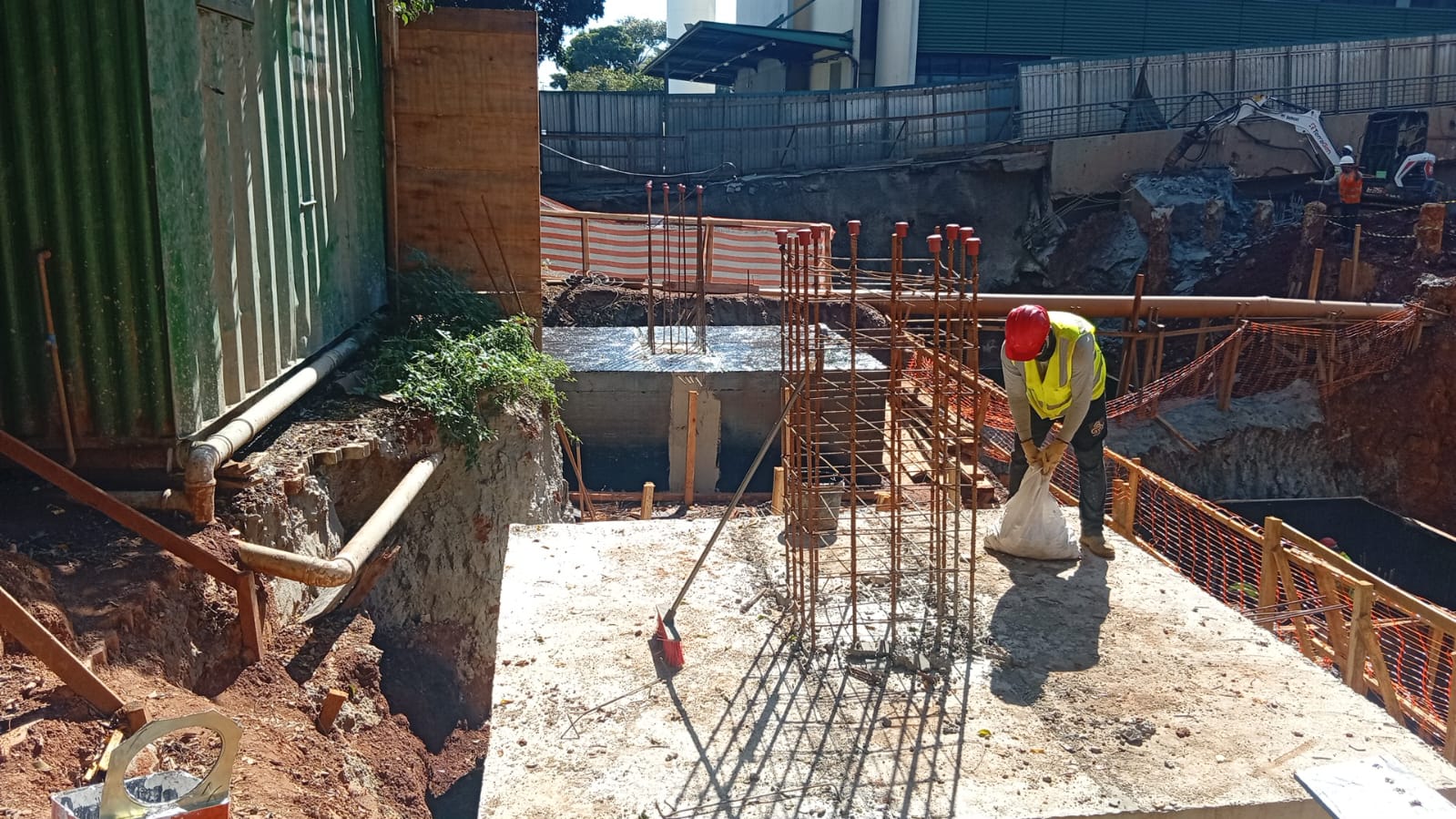 Operário da GPX ajustando armaduras de aço (ferragens) sobre bloco de concreto