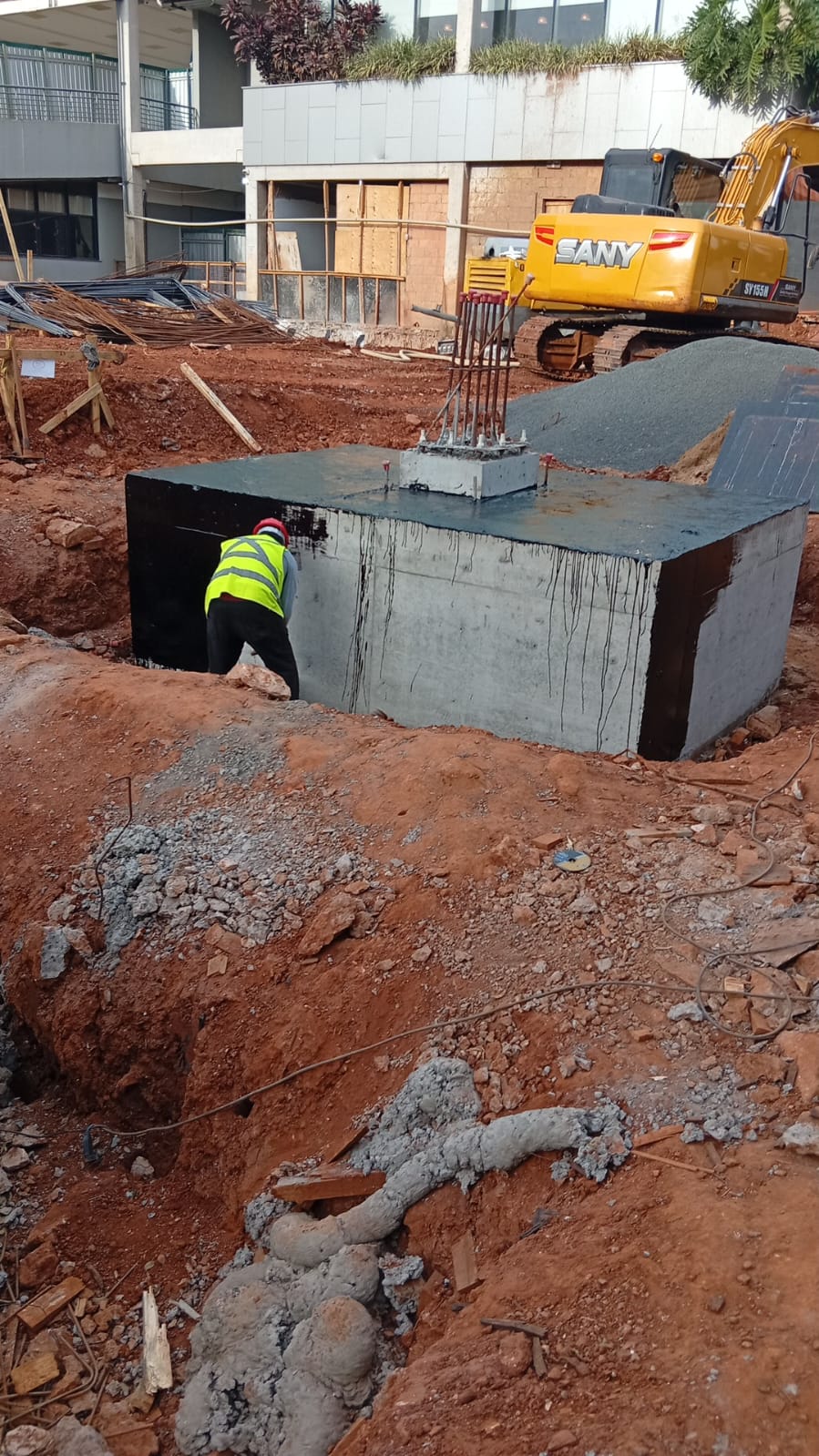 Bloco de coroamento de estaca recém-concretado mostrando armadura exposta
