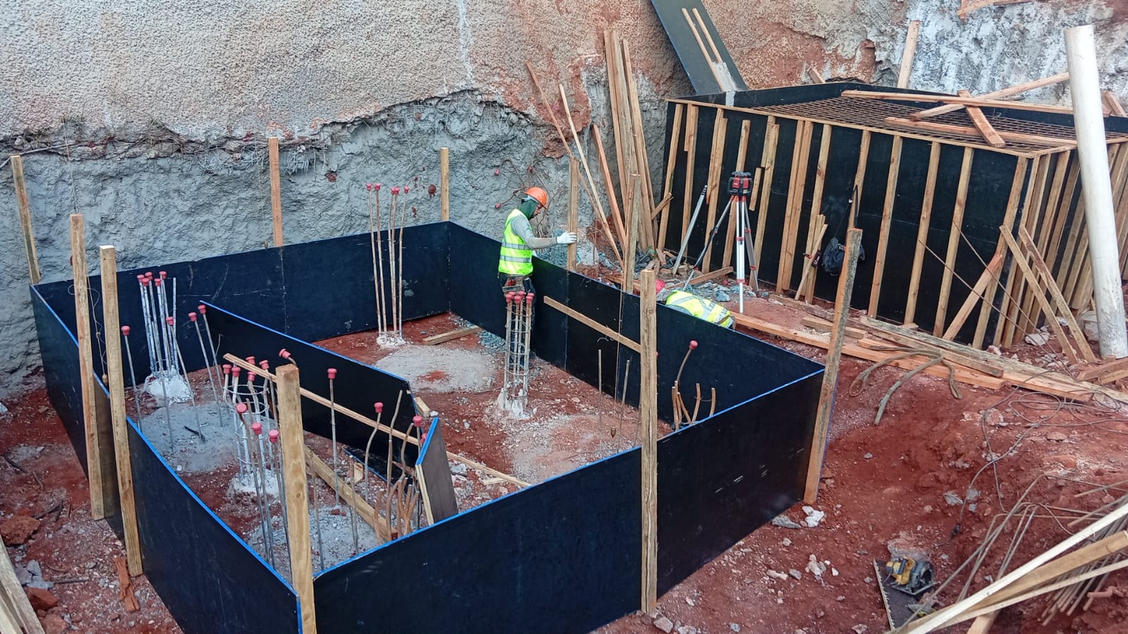 Obra de fundação em execução com formas de madeira, ferragens e arrasamento de estacas